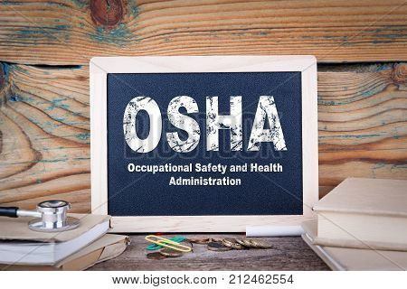 osha, Occupational Safety and Health Administration. Chalkboard on a wooden background.