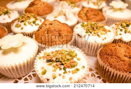 sweet and tasty carrot muffins with pistachios, sugar icing and  edible paper flowers