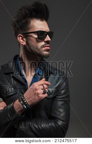 cut out image of a sexy un shaved man in leather jacket and sunglasses , looking to side ; we wears rings and bracelets