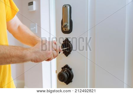 Closeup Of A Professional Locksmith Installing Or Repairing A New Deadbolt Lock