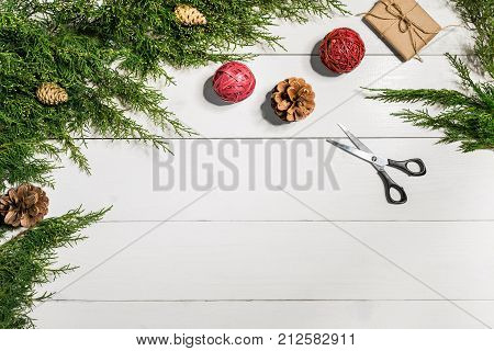Juniper branches with a Christmas decor. Christmas, New Year background. Coniferous branches of juniper. Top view, flat design. Christmas tree on white wooden background.