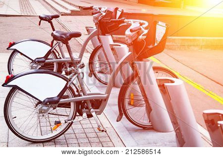 City bike rental system. Bicycle parts are large. Parking bicycles on city streets. With tinting and blurring