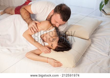 man wakes a woman in the bedroom in the morning weekend 1