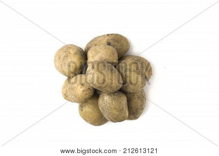 Pile of raw potatoes on a white background. Tubers of fresh, dirty potatoes close-up