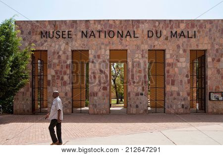 BAMAKO, MALI - CIRCA FEBRUARY 2012: A man walks past the Mali National Museum entrance gate.