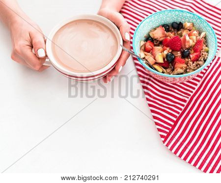 Healthy breakfast - cup of coffee, muesli and fresh berries on white wooden background, top view, health concept
