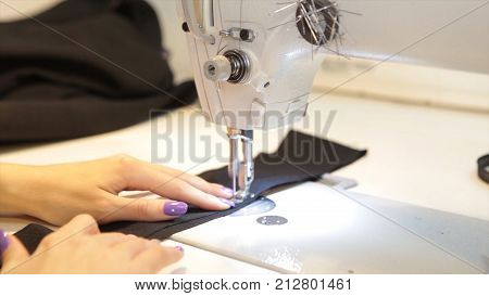 Sewing machine, seamstress sewing at machine and women's hands. Antique Sewing Machine Franklin. Young Woman Wears Protective Face Mask Working On Sewing Machine. Fashion HD