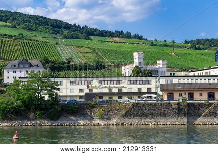 Panoramic view of the Asbach Confiserie (confectionery) with Rottland castle, the vineyards, and the floating cable cars in the background. Rudesheim am Rhein, Germany - August 1st 2015.