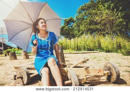 Asian women travel sleep relax. Women dress up hill tribe. Sitting on a wooden car Hill tribe. Thailand
