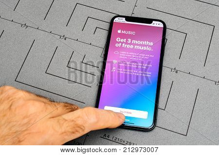 PARIS FRANCE - NOV 9 2017: Male hand touch selecting New Apple iPhone x 10 smartphone after unboxing and testing by choosing 3 free monts of Apple music