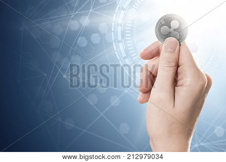 Hand Holding A Silver Ripple Coin On A Bright Background With Blockchain Network. Copy Space Include