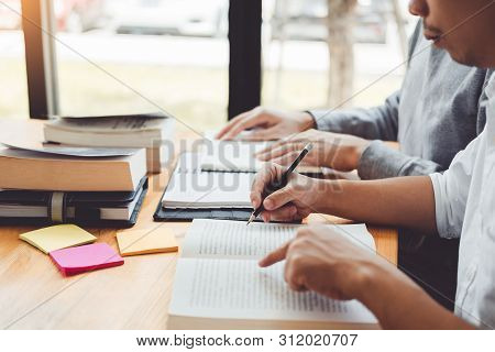 High School Or College Students Studying And Reading Together In Library
