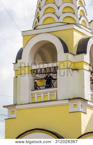 Kaluzhskiy Region, Russia - July 2019: Woman-ringer Is Ringing The Bells On The Bell Tower Of A Russ