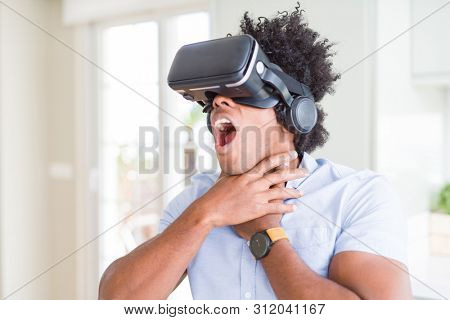 African amaerican man having fun playing with virtual reality glasses
