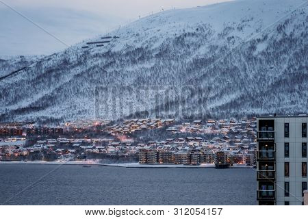 Residential Hillside Houses In Tromso Suburb Covered In A Deep Snow At Dusk, Norway