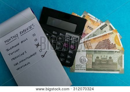 List Icons On Notepad And Calculator With Indian Currency On Blue Background. Medicine And Expenses 