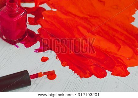 Spilled Nail Polish Colors Mixed Together With Bottle And Brush Next To Them