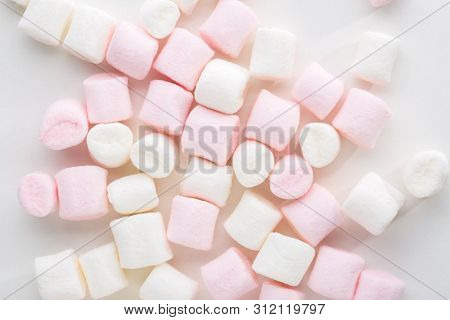 Mini marshmallows of white and light pink colors on white background.