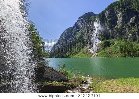 Mountain Lake Scenery With Waterfalls In Austria, Located In The Zillertal Alps Nature Park