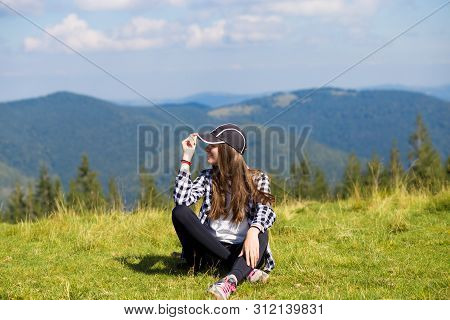 Successful Woman In Cap On Top Of Hill Enjoy View On Mountain Peak