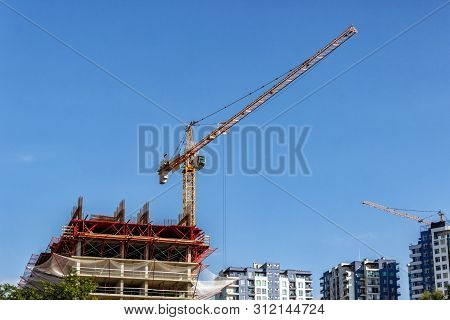 Towers Of The Cranes. Construction Site With Cranes Against The Blue Sky.
