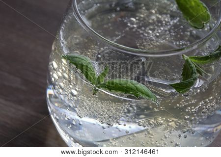 Refreshing Drink With Gas Bubbles. Nalit In A Transparent Glass. It Laid Crushed Ice. Decorated With