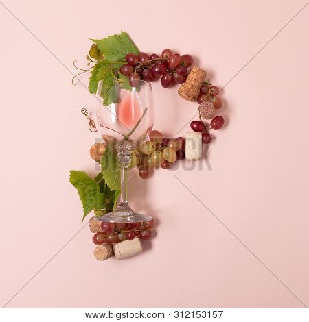 Alphabet. Letter P Made Of Wineglasses With Rose And White Wine, Grapes, Leaves And Corks Lying On P