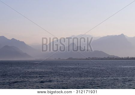 Mountains In A Blue Haze And Sunset Over The Sea