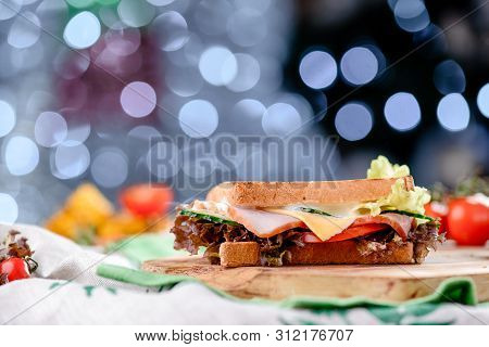 New Years Sandwich With Ham, Tomatoes, Onions, Cheese, Sauce And Lettuce On A Wooden Board. Against 