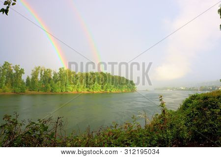 Rain Storm With A Rainbow In The Distance Surrounded By A Lush Temperate Forest Taken At The Willame