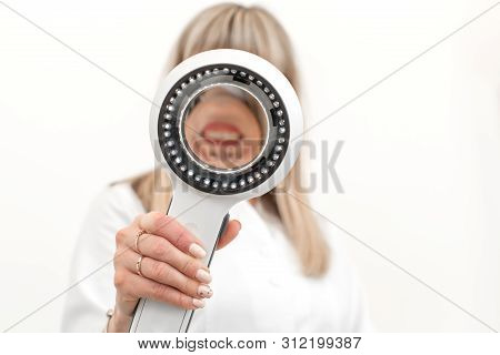The Doctor Trichologist Dermatologist Examines The Camera Through The Dermatoscope.