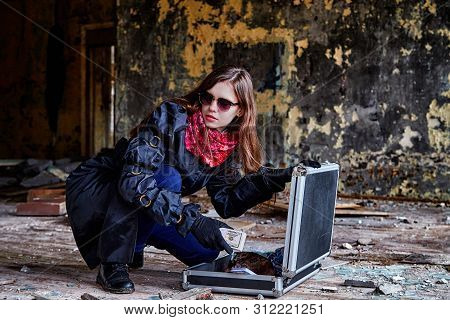 Girl In A Black Cloak With A Diplomat And Money In A Ruined Room. A Spy In A Secret Meeting. Unusual