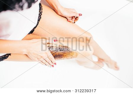 Slim Young Woman In A Bright Silk Pajamas Scrabs Her Leg Sitting In A Big Beautiful Bright Bath. Ski