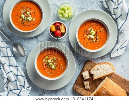 Gaspacho Soup On White Marble Tabletop. Three Bowls Of Traditional Spanish Cold Soup Puree Gaspacho 