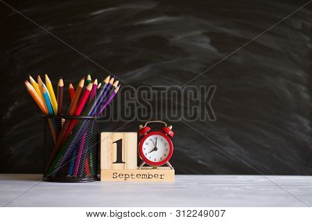 Concept Back To School. Re Alarm Clock With Color Pencils And Wooden Calendar Set On 1St September O