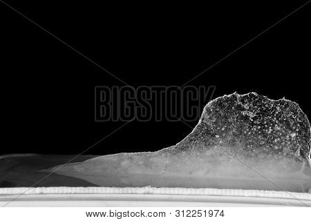 Ice Melting. High Contrast, Black Background. Small Bubbles In Ice.