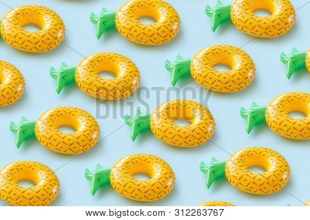 Seamless Pattern With Inflatable Penapples On A Blue Background.