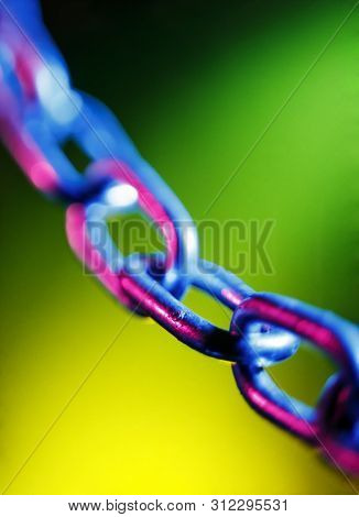 Abstracted Short Depth Of Field Image Of Chain Links, On A Colourful Green And Yellow Background
