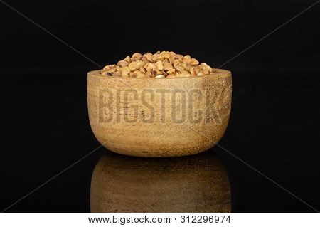 Lot Of Whole Raw Brown Buckwheat Grain In A Wooden Bowl Isolated On Black Glass