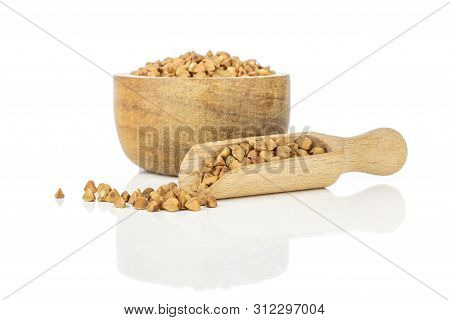 Lot Of Whole Hulled Raw Brown Buckwheat Grain In A Wooden Bowl With Wooden Scoop Isolated On White B