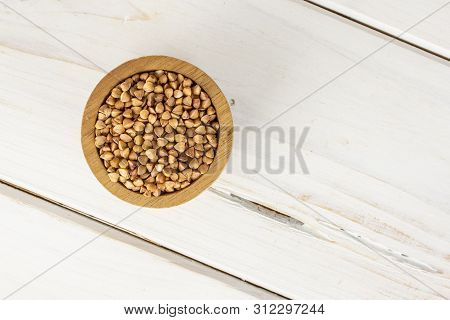 Lot Of Whole Raw Brown Buckwheat Grain Copyspace In A Wooden Bowl Flatlay On White Wood