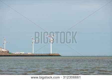 Knokke-heist, Flanders, Belgium -  June 18, 2019: Lng Terminal In Port Of Zeebrugge Has Windmils, Bu