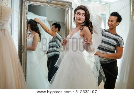 Beautifu bride choosing wedding dress in a wedding salon