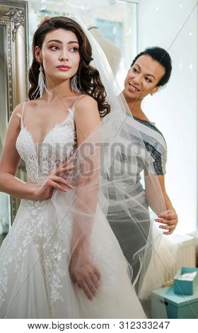 Beautifu bride choosing wedding dress in a wedding salon