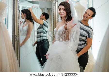 Beautifu bride choosing wedding dress in a wedding salon