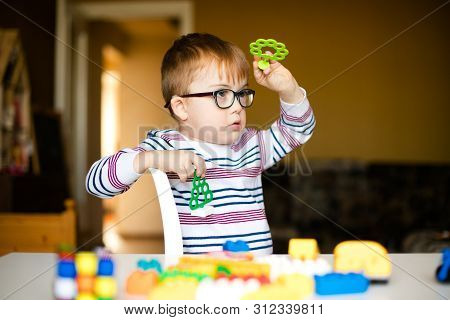 Little Ginger Boy With Glasses With Syndrome Dawn Playing With Color Blocks