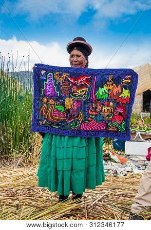 Uros, Peru- Jan 5, 2019: Inhabitants of Uros floating islands sell the rugs, Titicaca lake, Peru.