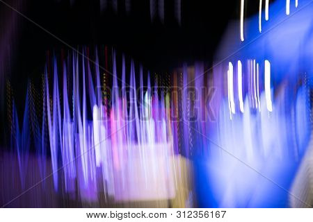 Abstract Of Multicolored Lights Stripes Moving Fast In Dark Background. Orange Violet And Bluel Back