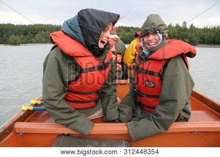 Glacier Point, Alaska - August 2, 2006 - Two Young Girls In Rain Gear And Life Jackets Enjoy Canoe R