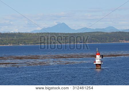 Inside Passage, Alaska - August 5, 2006 - Channel Marker On The Inside Passage With Mountains In The